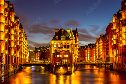 Fototapeta Naklejka Na Ścianę i Meble -  The Warehouse district Speicherstadt during twilight sunset in Hamburg, Germany. Illuminated warehouses in Hafencity quarter in Hamburg.