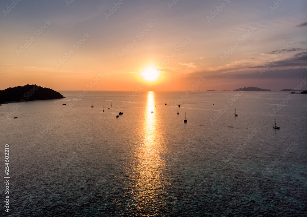 Sunset over horizontal with yacht on sea