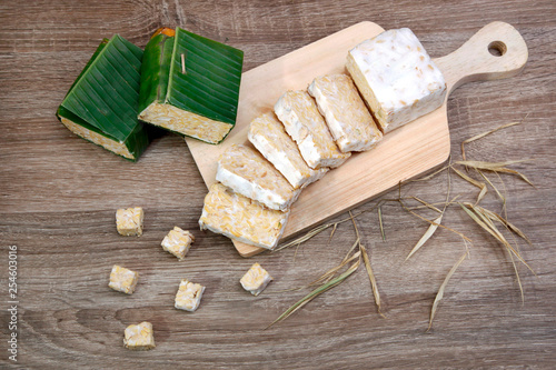 Photos slices of raw tempeh on cutting board