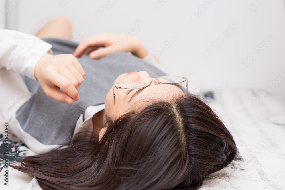 Naklejka premium Asian beautiful glasses women lying on bed in living room