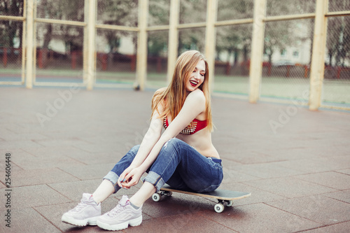 Blondie sexy pretty gorgeous beauty girl from sport support team posing on stadium with skateboard. Sport, active life, beauty concept