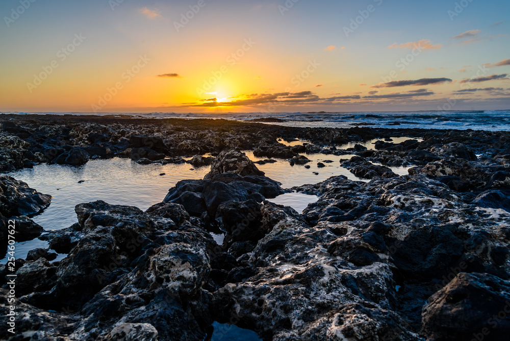 Fototapeta premium Scenic view of rocky beach at sunset