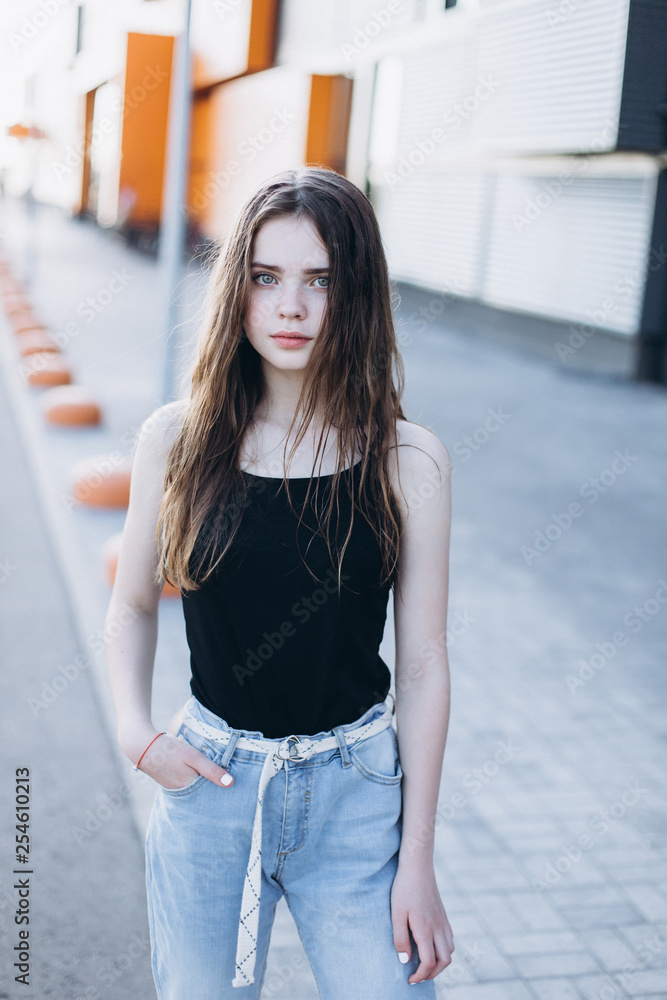 Cute cheerful portrait of young teenage girl outdoors in the street . Emotions, portrait, beauty concept