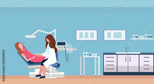 female dentist doctor examining woman patient lying in dentistry chair professional dental office modern clinic interior female characters full length flat horizontal