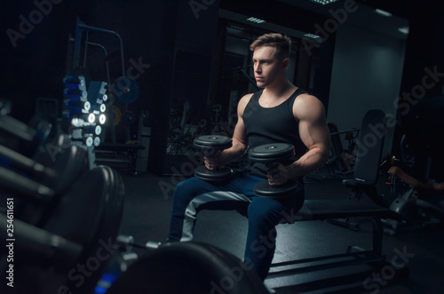 the sporty boy trains with dumbbells