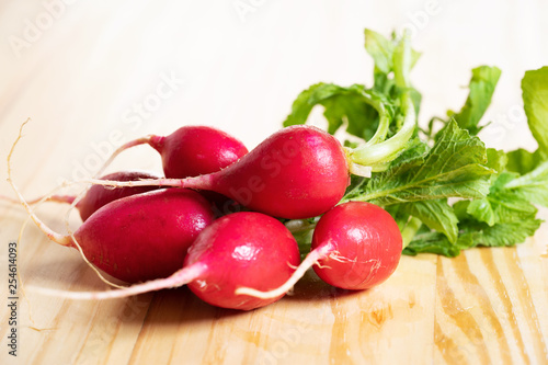 Fresh red radishes on wooden table