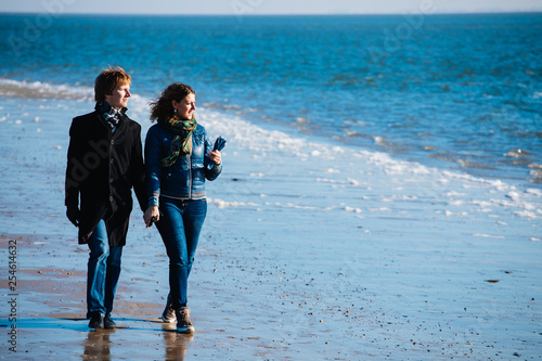 Vászonkép Curly girl and a guy in a coat holding hands