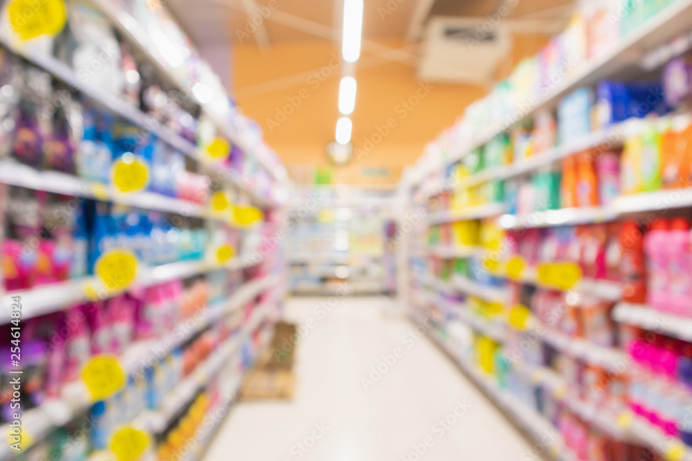supermarket aisle with detergent and household product shelves interior defocused blur background