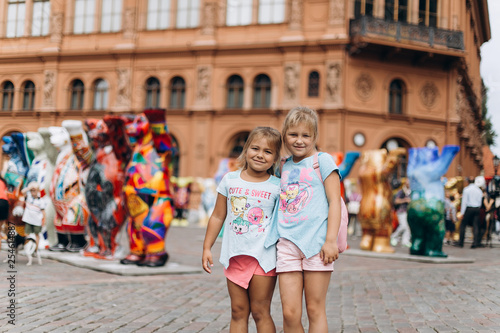Two adorable little girls, sisters walking in old town in Riga together . Childhood, travelling concept