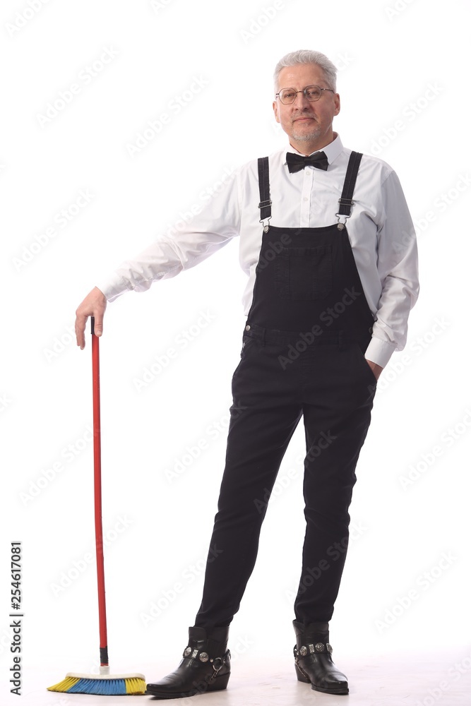 Gray-haired cleaner, janitor in a black jumpsuit with a mop and dustpan provides cleaning service, on white background Gray-haired cleaner, janitor in a black jumpsuit with a mop and dustpan provides cleaning service, on white background