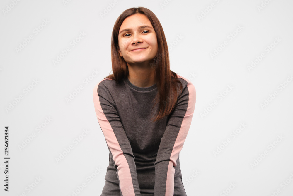 attractive young brunette girl cute smiling looking at the camera. Studio shot on isolated gray background attractive young brunette girl cute smiling looking at the camera. Studio shot on isolated gray background
