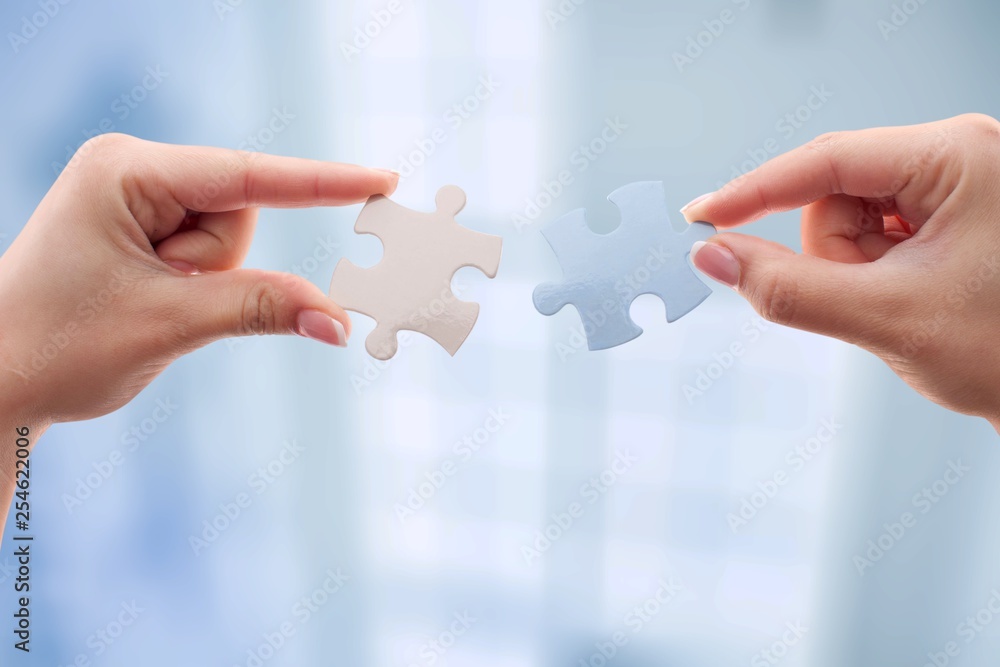 Human hands joining puzzle parts on background Human hands joining puzzle parts on background