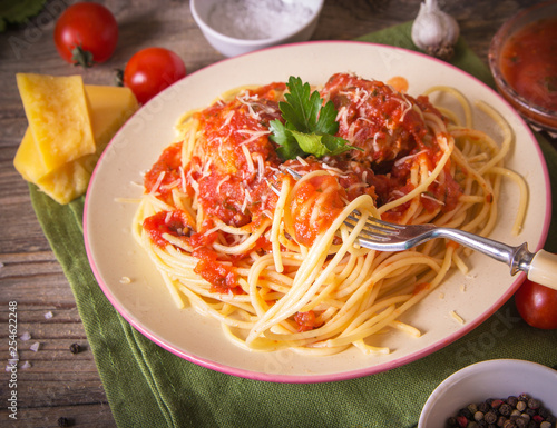 Italian cuisine spaghetti with meatballs noodles pasta meal in a plate on a rustic wooden background