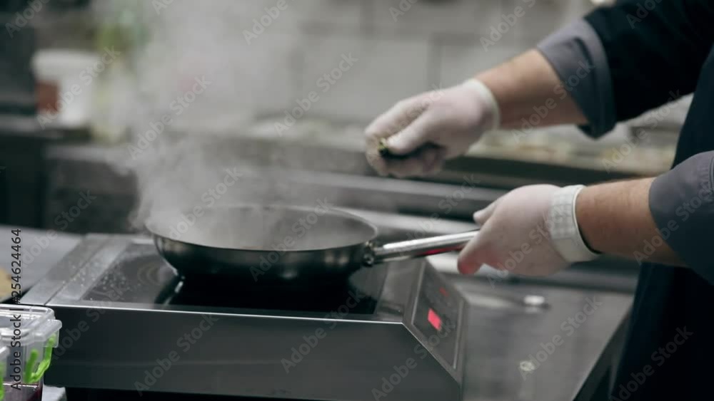 Man cooking meat steak on kitchen. Flambe Man cooking meat steak on kitchen. Flambe