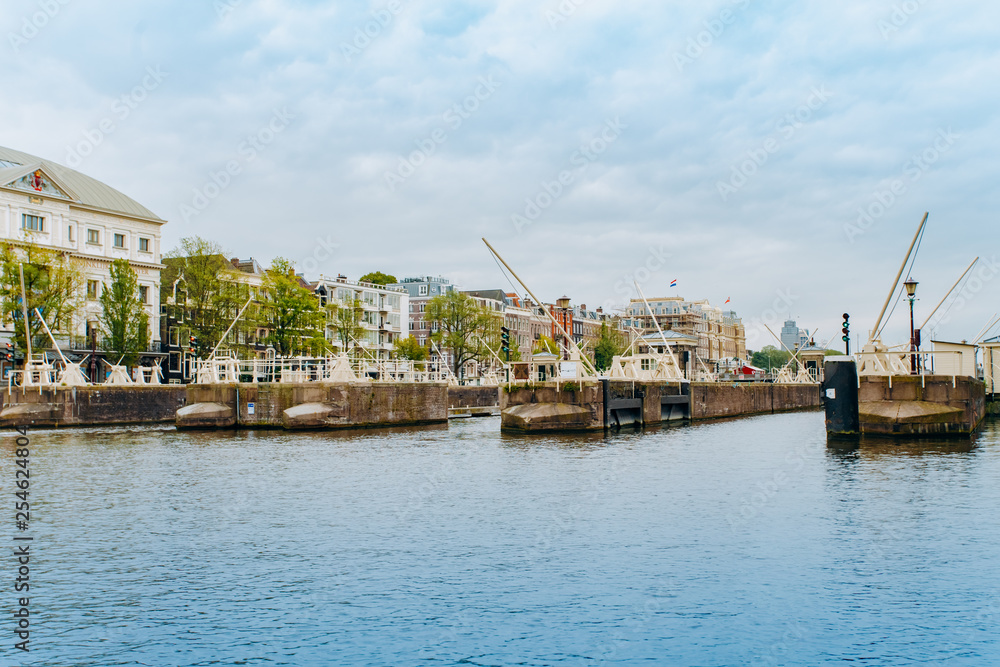 Amsterdam, Netherlands September 5, 2017: Reflection of trees and houses in still water of Amstel river, Amsterdam, Netherlands. Amsterdam, Netherlands September 5, 2017: Reflection of trees and houses in still water of Amstel river, Amsterdam, Netherlands.