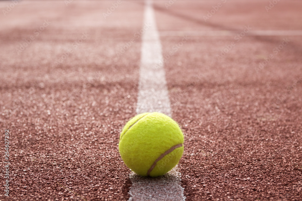 Isolated tennis ball on the court line 