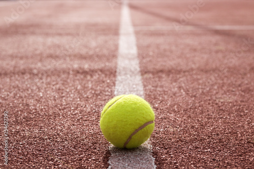 Isolated tennis ball on the court line 