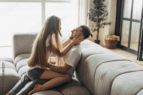 Young romantic couple is kissing and enjoying the company of each other at home photo