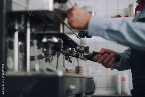 Man preparing professional coffee machine in cafe