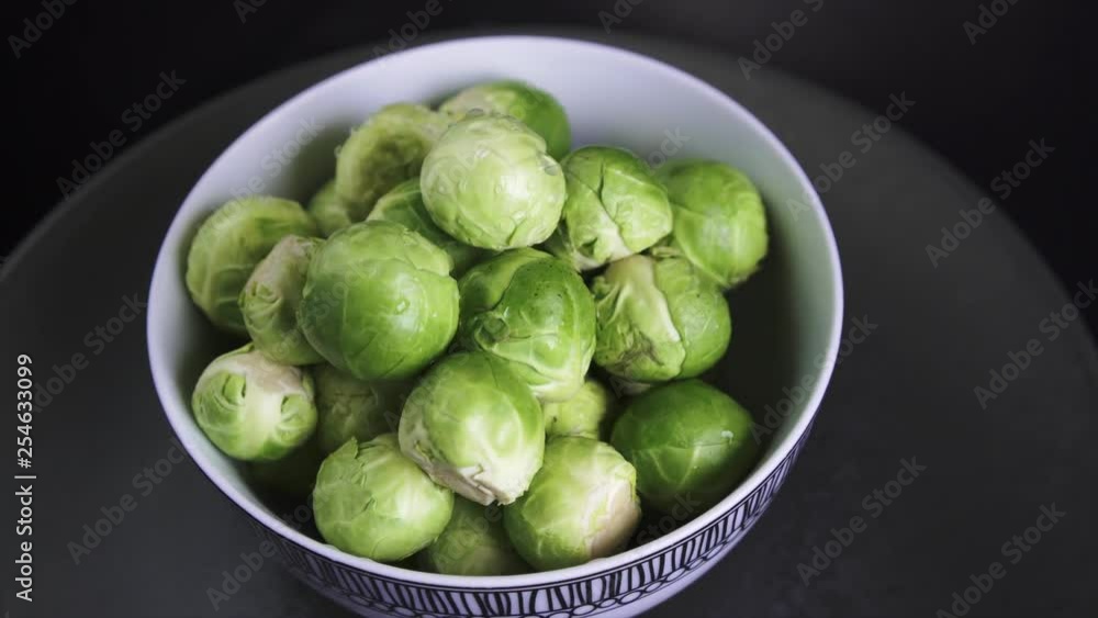 Fresh and Wet Brussel Sprouts rotating on Black Background, 4k. Fresh and Wet Brussel Sprouts rotating on Black Background, 4k.