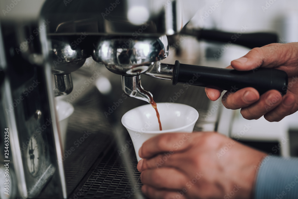 Man making espresso with professional coffee machine