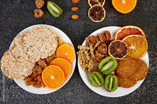 Healthy snacks - variety oat granola bar, rice crips, almond, kiwi, dried orange