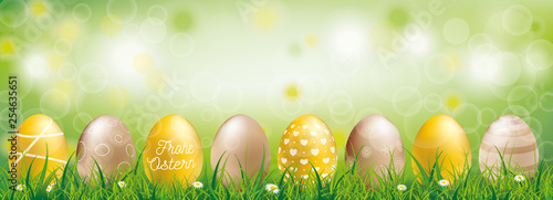 Frohe Ostern Banner mit goldenen Ostereiern im Gras