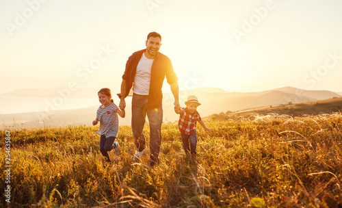 happy family father and children in nature at sunset.