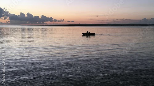 Father and son in a rowboat. Silhouettes of two people boating at sunset.
