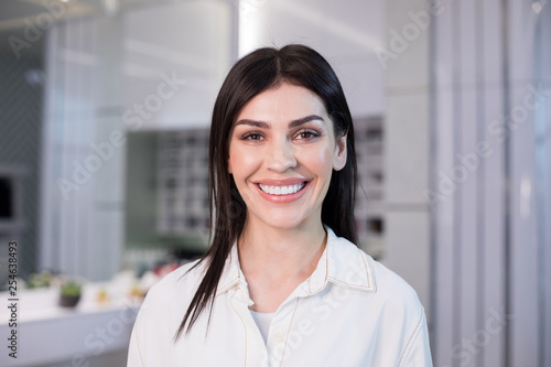 Portrait of happy woman with beautiful makeup situating in barber shop