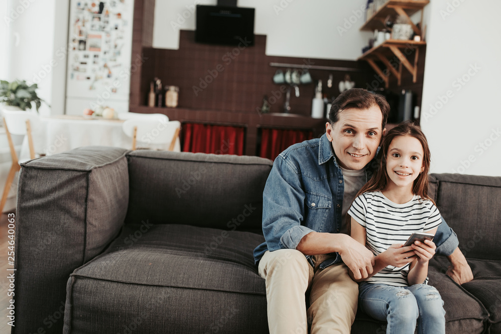 Father and daughter sitting on sofa at home Father and daughter sitting on sofa at home
