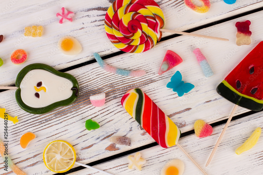 Colored candies, sweets and lollipops. Mixed candies on vintage wooden background.