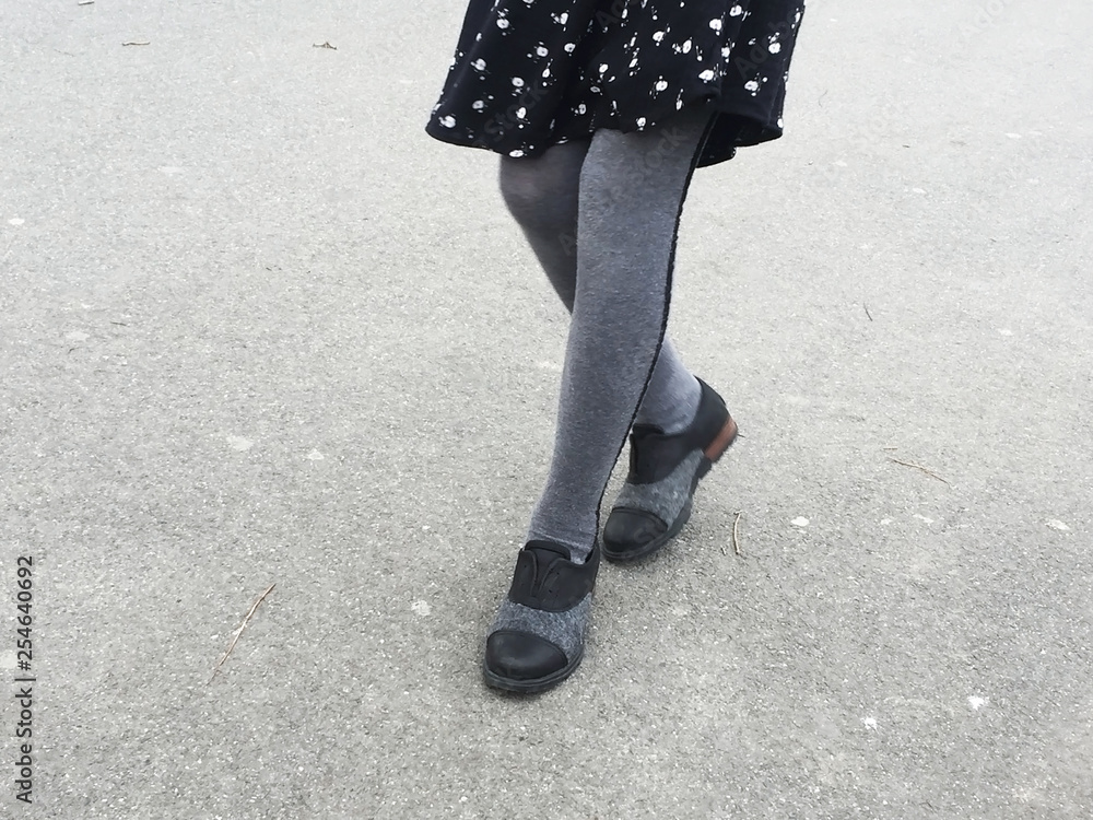 View of girl's legs playing on asphalt View of girl's legs playing on asphalt