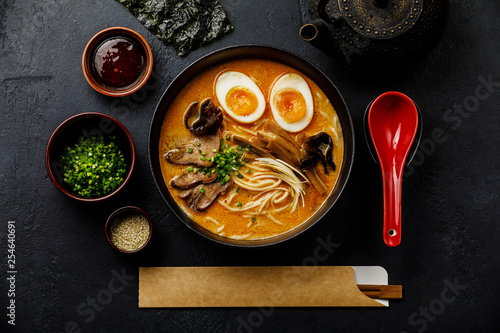 Ramen asian noodle in broth with Beef tongue meat, mushroom and Ajitama pickled egg in bowl on dark background photo