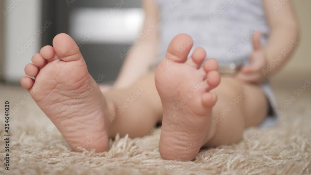 Baby foot at white carpet, close up. Baby foot at white carpet, close up.