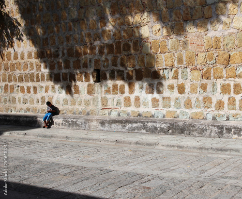 a child leaning against a rough wall