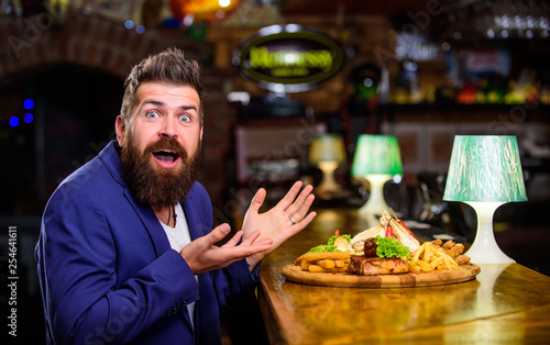 Enjoy meal. Cheat meal concept. Hipster hungry eat pub fried food. Restaurant client. Hipster formal suit sit at bar counter. Man received meal with fried potato fish sticks meat. Delicious meal
