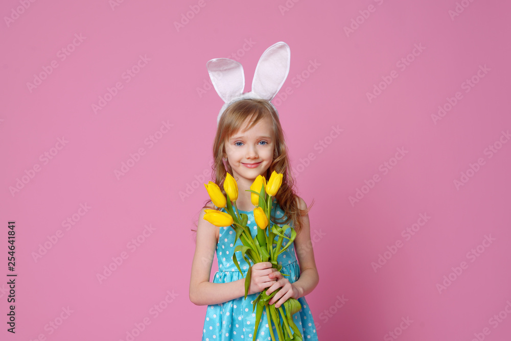 Cute little girl in the form of an Easter Bunny with a bouquet of yellow tulips. concept of holidays, fashion and beauty. Happy Easter! Selective focus.