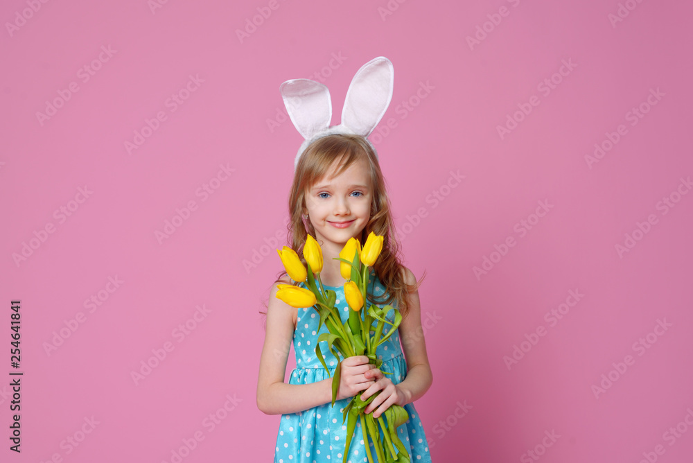 Cute little girl in the form of an Easter Bunny with a bouquet of yellow tulips. concept of holidays, fashion and beauty. Happy Easter! Selective focus. Cute little girl in the form of an Easter Bunny with a bouquet of yellow tulips. concept of holidays, fashion and beauty. Happy Easter! Selective focus.