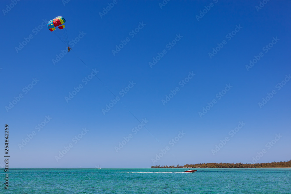 Parasailing in clear blue sky above the turquoise water near tropical island Mauritius Parasailing in clear blue sky above the turquoise water near tropical island Mauritius