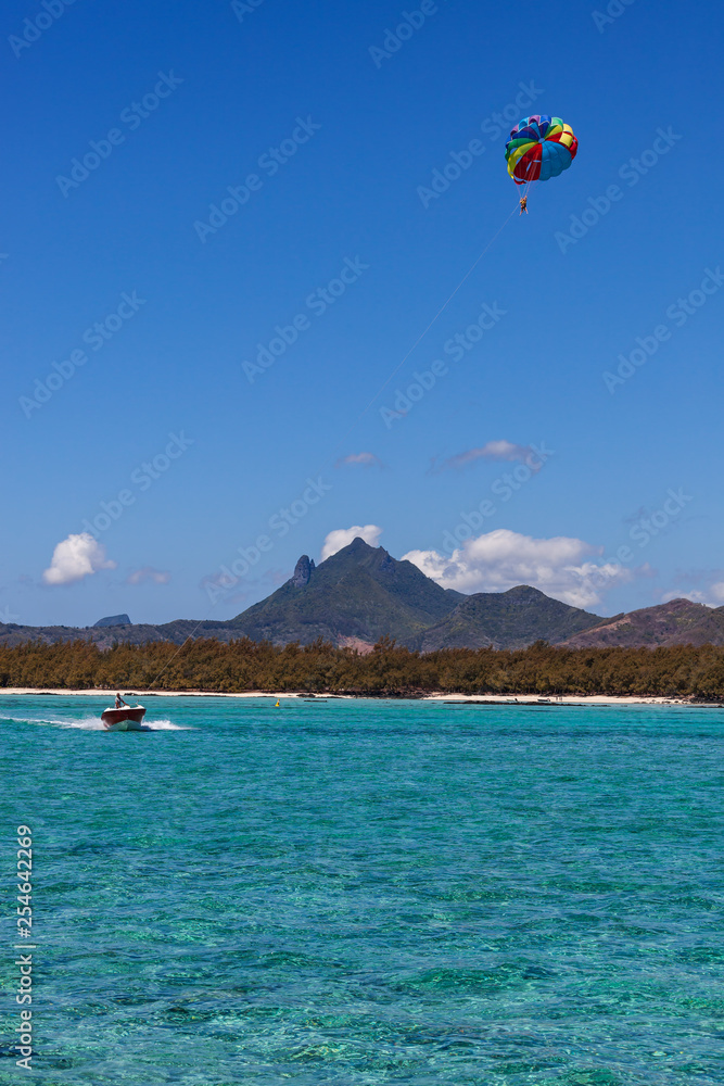 Parasailing in clear blue sky above the turquoise water near tropical island Mauritius Parasailing in clear blue sky above the turquoise water near tropical island Mauritius