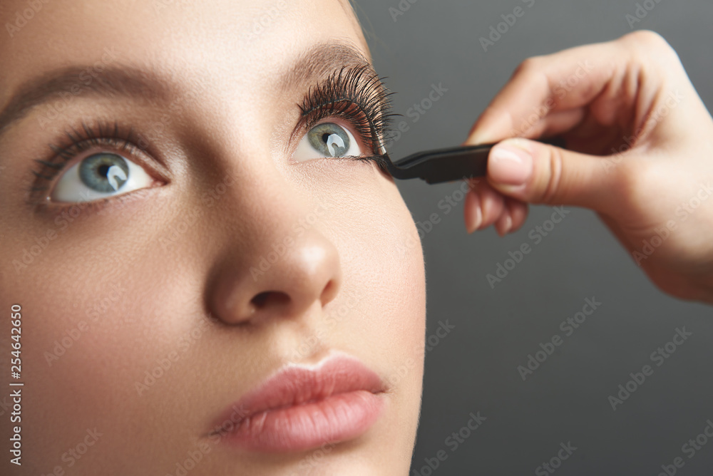 Woman staying calm while getting false eyelashes