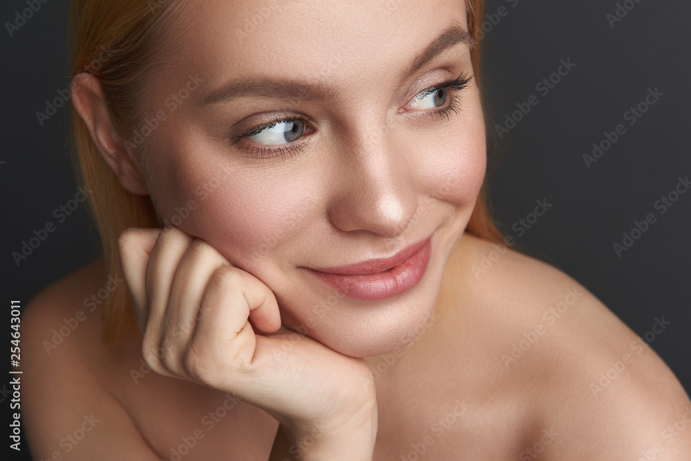 Portrait of pleased woman with natural makeup looking away