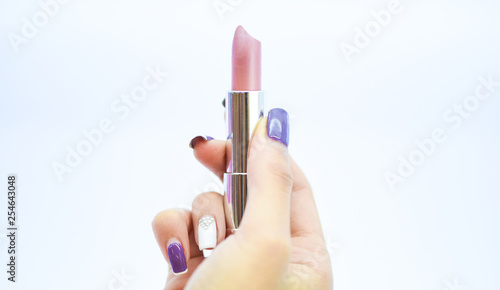 Must have. Beauty trend. Daily make up. Soft lipstick including balm. Lipstick for professional make up. Lip care concept. Lipstick on white background. High quality lipstick product in female hand