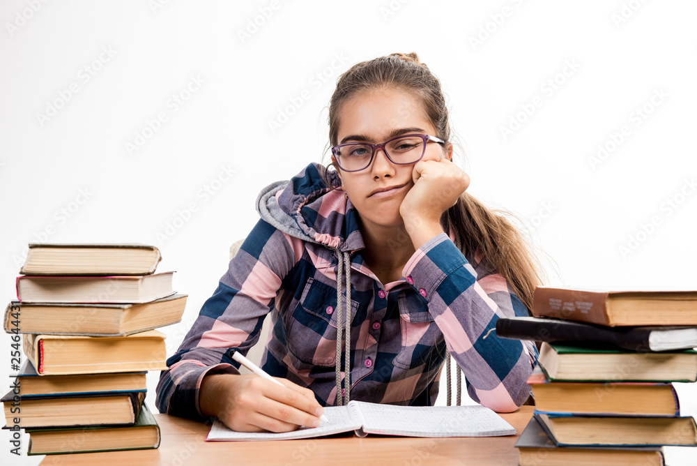 Girl with books. student is sitting at the table with books. smiling student at school desk. exams at school. Education. Printed books, study at school. Library. Girl with books. student is sitting at the table with books. smiling student at school desk. exams at school. Education. Printed books, study at school. Library.