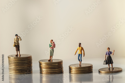 Concept of Retirement Money Plan and savings growth. Old and young woman stand on stacks of gold coins isolated on white and orange background.