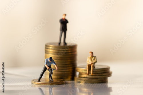 Small businessman figures standing on turning poing. The concept of role conflict in society and at home. money saving. Investment concept. retirement concept.