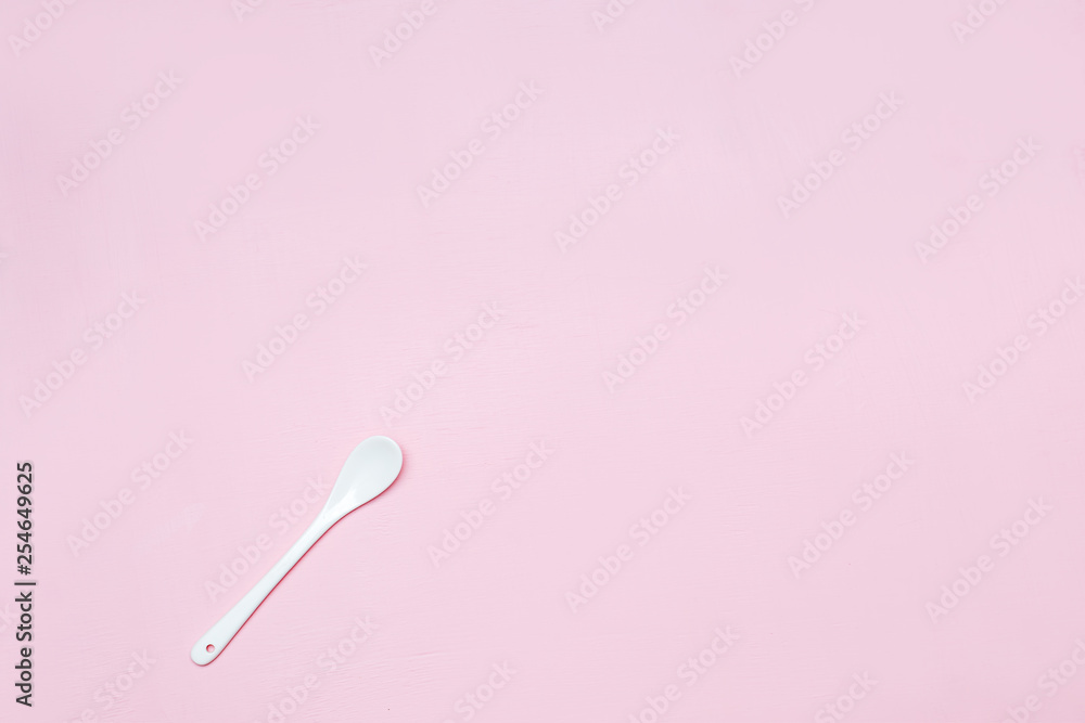 Ceramic white spoon on a pink background copy space Ceramic white spoon on a pink background copy space