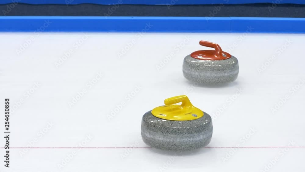 Yellow Curling stone hits another yellow stone