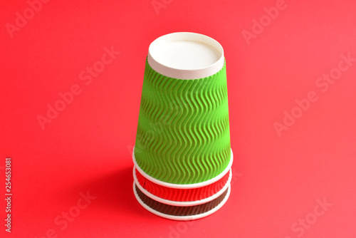 Red  green  brown paper cups on a red background. Copy space.